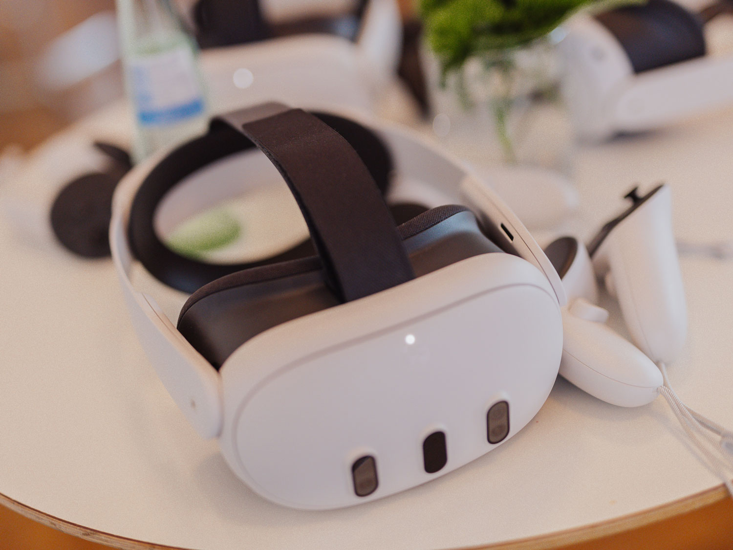 A white VR headset with a sleek, rounded shape resting on a table.