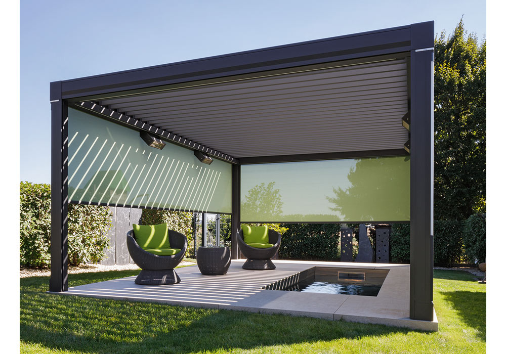 Modern overhang with green shading, featuring rounded chairs and a small pool in a landscaped area.