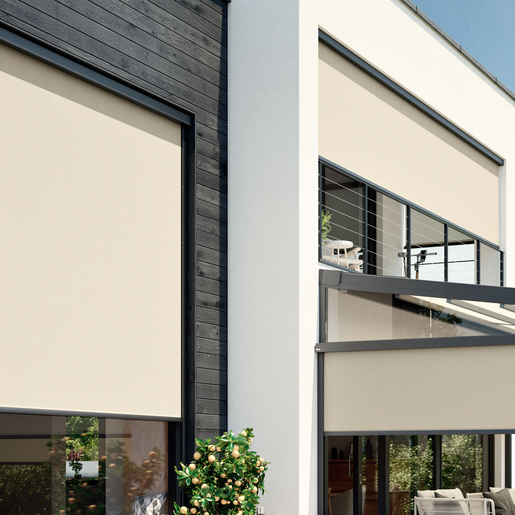 Moderne Hausfassade mit beigen Markisen und großen Fenstern, umgeben von einer grünen Terrassensituation.