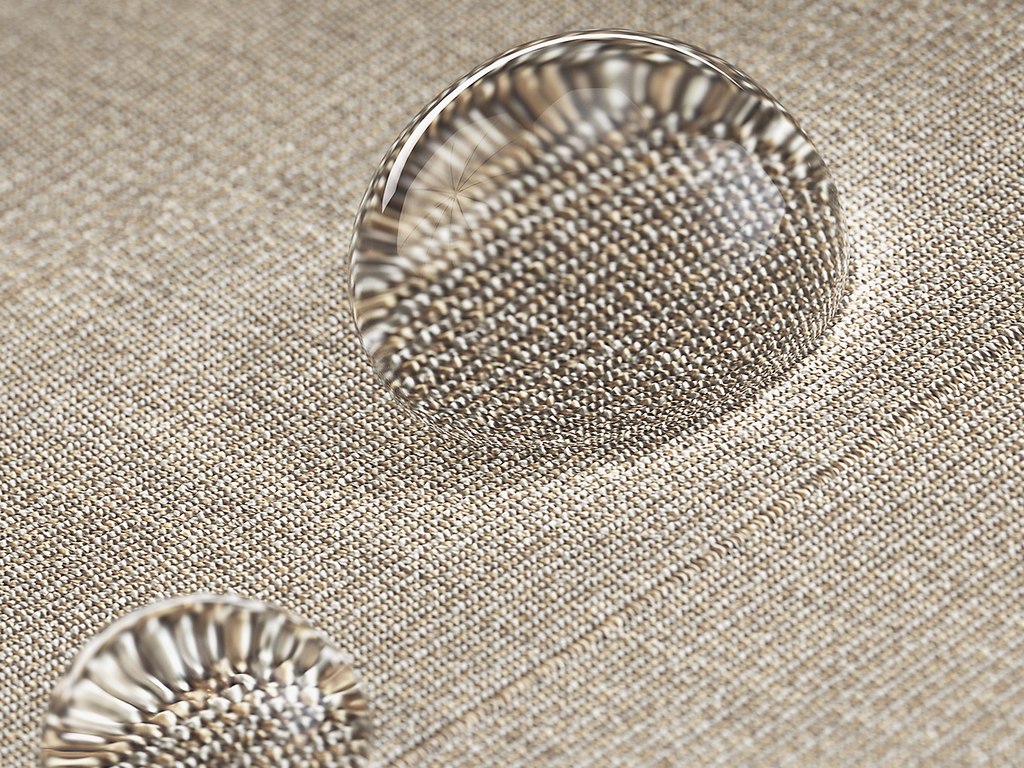 Close-up of water droplets on a textured beige surface.
