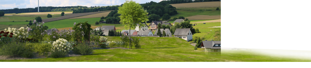 A rural landscape with green fields, trees, and small houses under a clear sky.