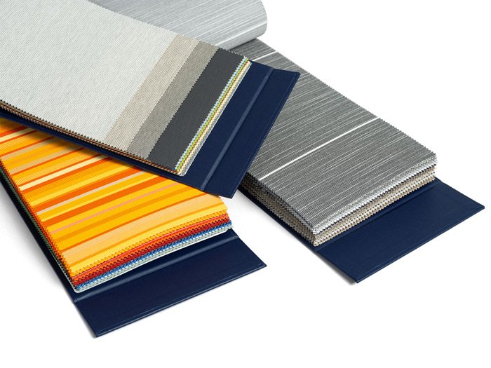 Fabric swatches in various colours, including grey, blue, and vibrant orange and yellow stripes. Fabric swatches in various colours, including grey, blue, and vibrant orange and yellow stripes.