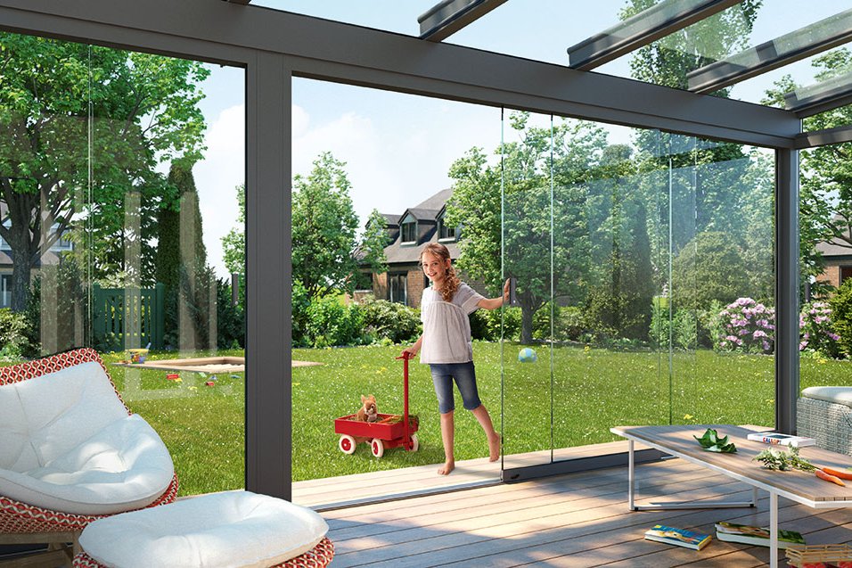 A bright, spacious winter garden with glass walls and a view of a lush green garden. A bright, spacious winter garden with glass walls and a view of a lush green garden.