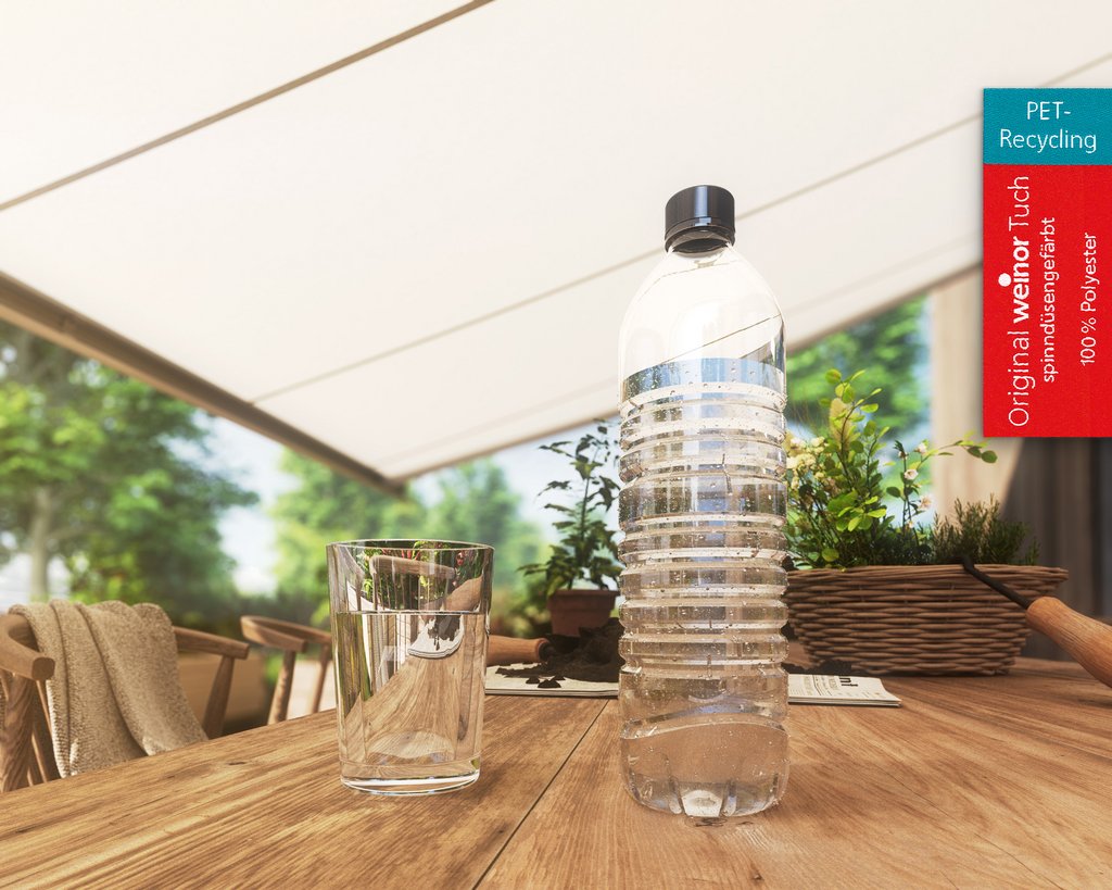 A water bottle and a glass on a table, with a soft-focus garden in the background.