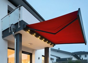A red awning extended over a terrace, featuring integrated LED lights along the edge. 