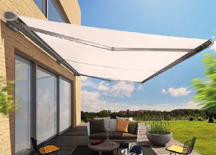A white awning extends over a patio area, providing shade and enhancing the outdoor space. 