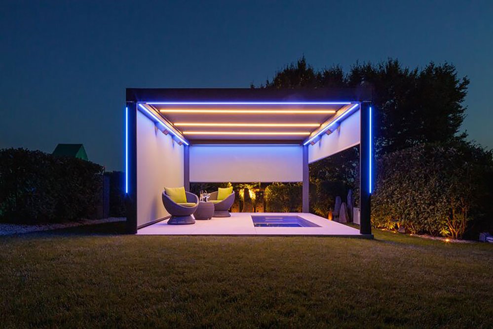 A modern terrace with a dark structure, illuminated by blue and warm lights at night. A modern terrace with a dark structure, illuminated by blue and warm lights at night.