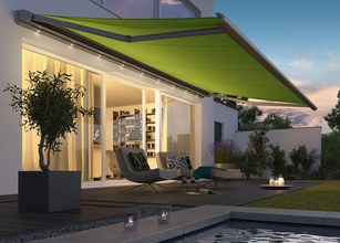 A green awning extended over a terrace with modern seating and soft ambient lighting in the background. 