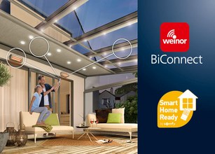 A couple interacts under a modern structure with lighting, featuring smart home technology branding. 