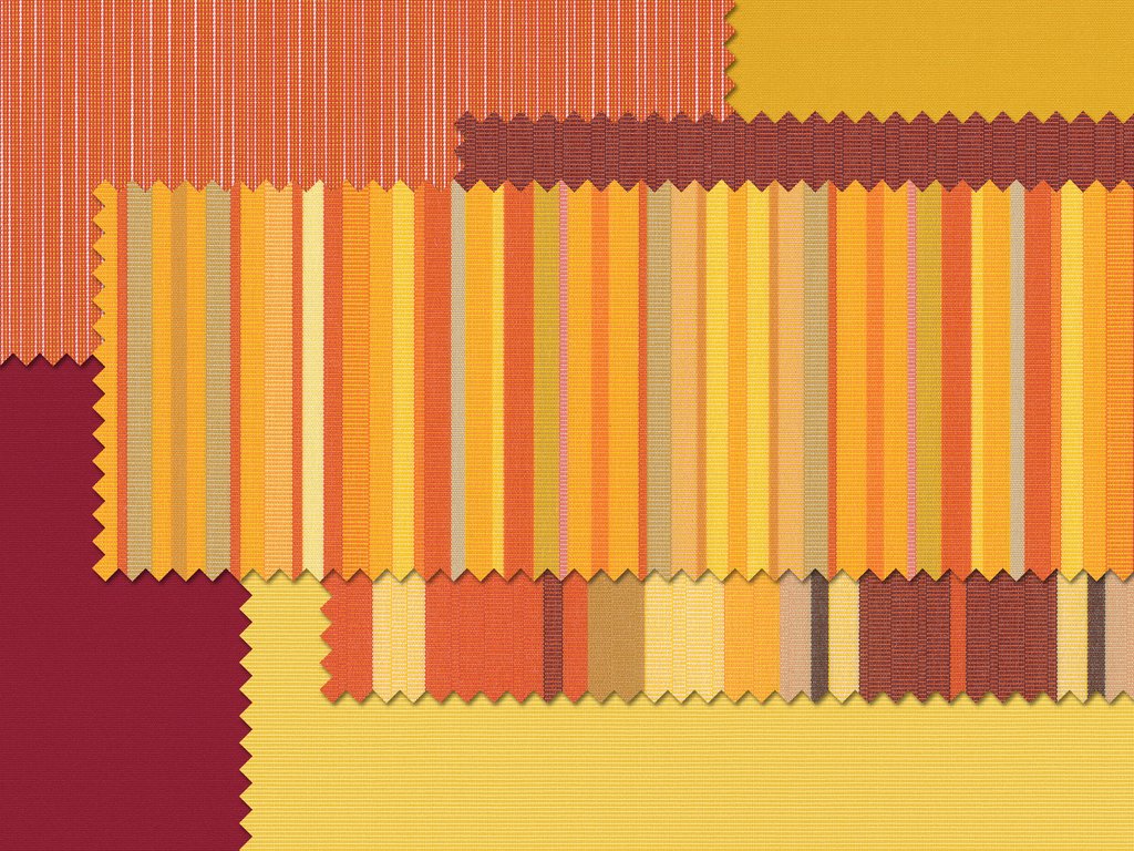 A collage of fabric swatches featuring warm colours like red, yellow, and orange in striped and patterned designs.