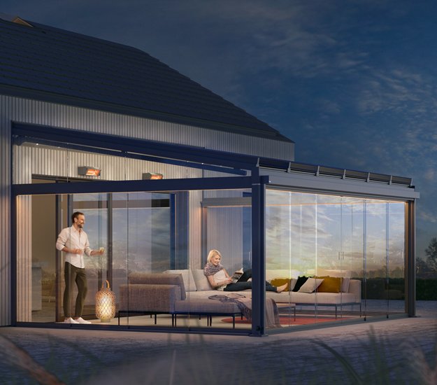 Outdoor living space with a glass extension, featuring a sleek design and warm atmospheric lighting. 