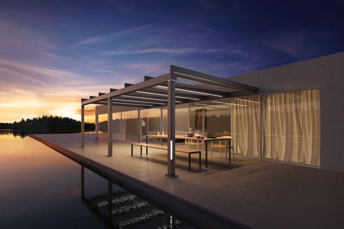A modern terrace with an overhead structure and a view of water at sunset. A modern terrace with an overhead structure and a view of water at sunset.