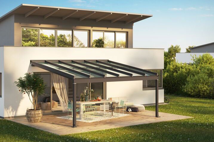A modern house with a flat roof, featuring a glass-covered terrace and surrounding greenery. A modern house with a flat roof, featuring a glass-covered terrace and surrounding greenery.