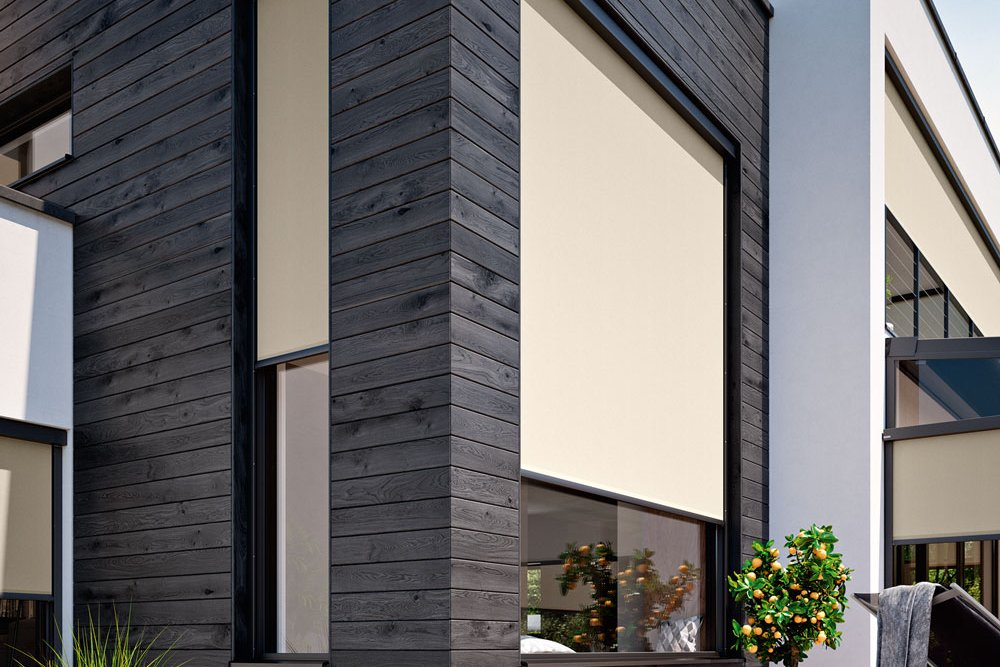 A modern building corner featuring beige awnings, large windows, and a wooden deck. A modern building corner featuring beige awnings, large windows, and a wooden deck.