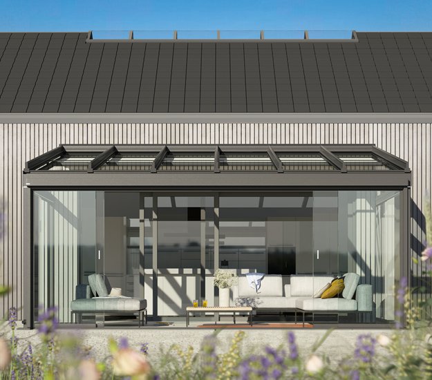 Glass extension with a dark frame, showcasing an open space and seating arrangement. Dominant colours are black and transparent. 