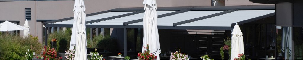 patio area with overhanging shading, featuring multiple tall white umbrella structures. patio area with overhanging shading, featuring multiple tall white umbrella structures.