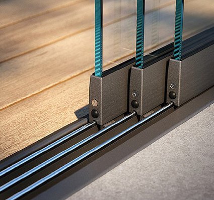 Close-up of glass sliding panels on a track, featuring a wooden surface beneath.