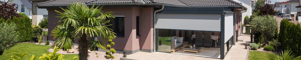 A modern house with a flat roof, large glass sliding walls, and a green garden area. A modern house with a flat roof, large glass sliding walls, and a green garden area.
