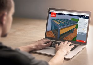 A person using a laptop to interact with a 3D model of a structure, displaying design elements on the screen.