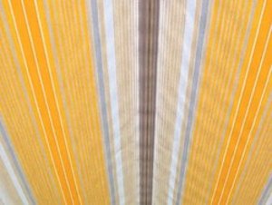 Striped fabric in yellow, grey, and brown tones, displaying a rhythmic vertical pattern.