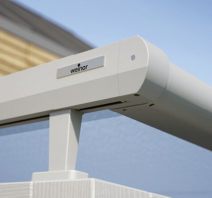 A close-up of a white awning box against a blue sky, featuring a sleek, modern design.