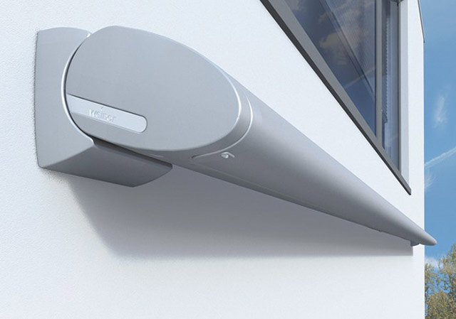 Sleek grey awning mounted on a white wall, featuring a modern, elongated design.
