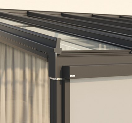 Close-up of a glass roof structure with a dark frame and a soft, light-coloured fabric feature.