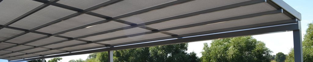 A rectangular overhead structure with a grey cover and metal framework against greenery. A rectangular overhead structure with a grey cover and metal framework against greenery.