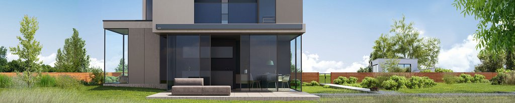 Modern house with large glass panels, surrounded by greenery and a patio area.