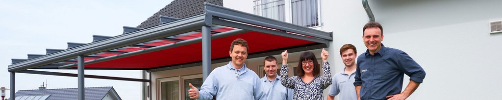 A group of people celebrating under a covered structure with a red roof.