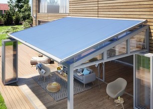 A modern terrace with a blue roof overhang and glass walls, featuring a spacious outdoor seating area. 