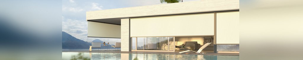 Modern house with a flat roof and large glass elements, overlooking a tranquil pool and mountainous landscape.