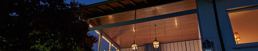A softly lit terrace with a wooden ceiling, showcasing warm hues and a cosy atmosphere. A softly lit terrace with a wooden ceiling, showcasing warm hues and a cosy atmosphere.