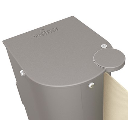 Close-up of a grey awning box with a rounded top and unfolding awning fabric.
