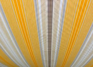 Striped fabric with shades of yellow, white, and beige in a rounded design. 